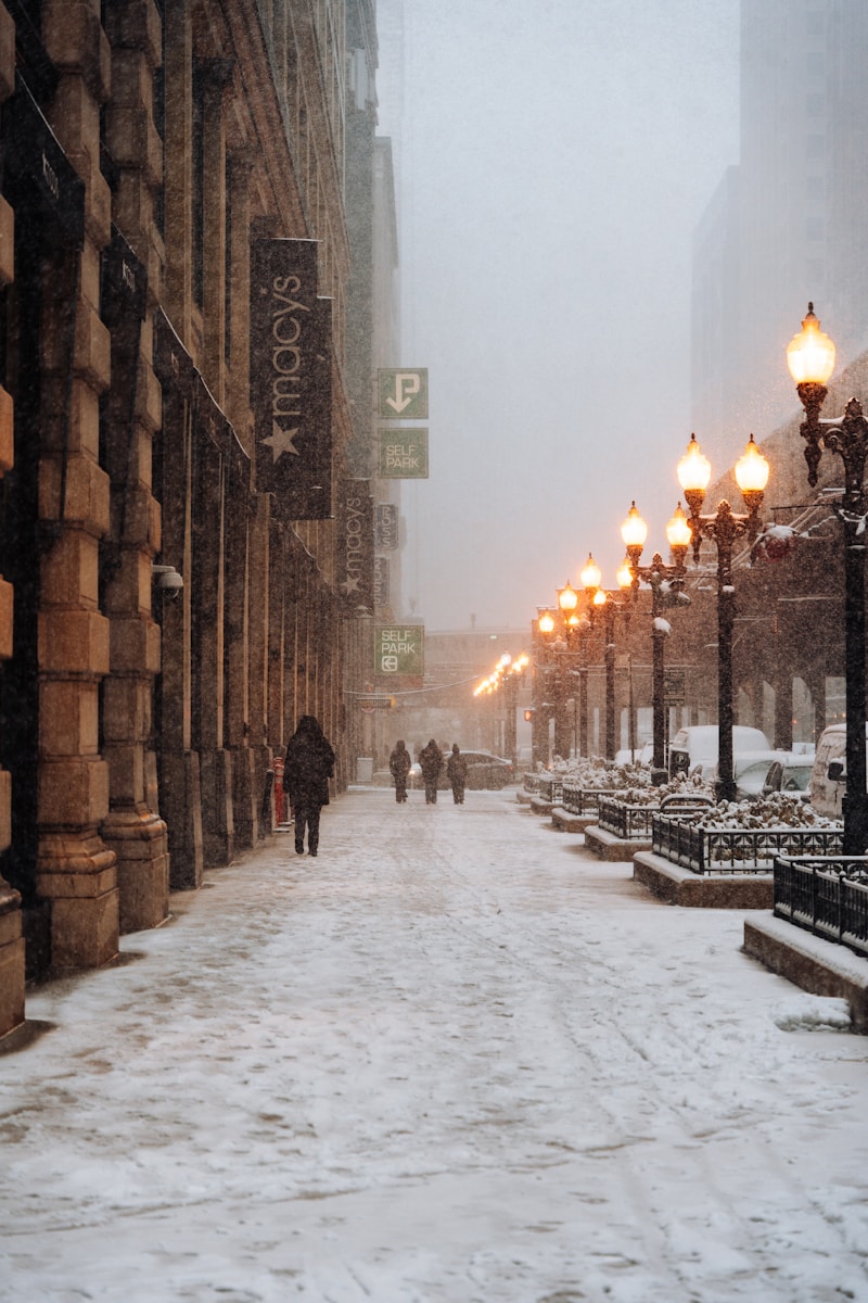 A snowy street with people walking down it